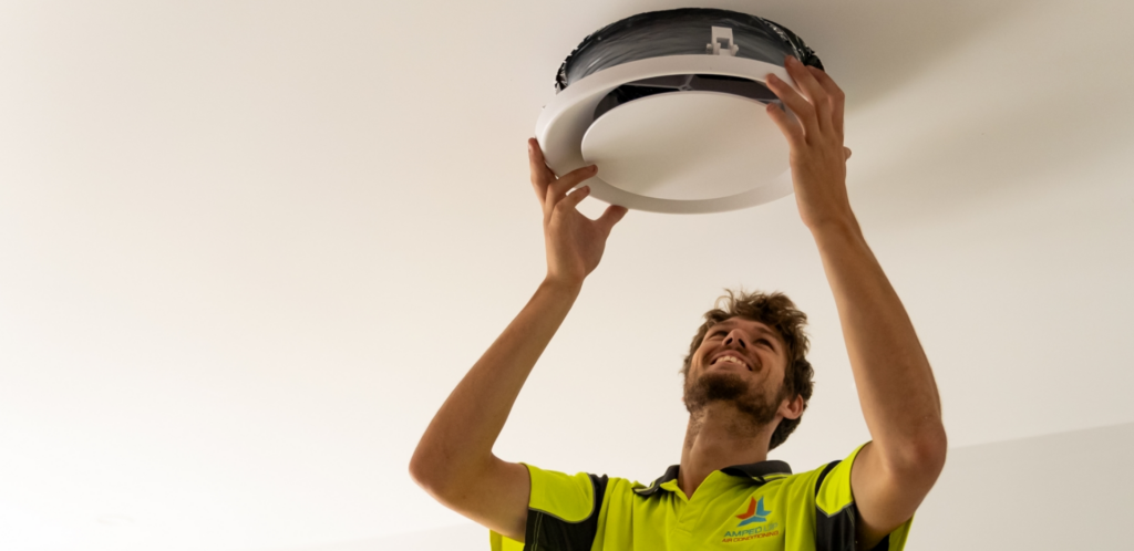 Amped Up Air technician installing a ceiling air vent in a Western Sydney home
