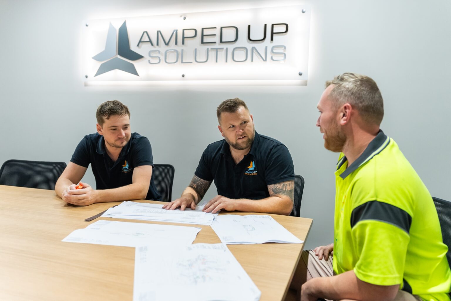 Amped Up Air team reviewing plans with a commercial client