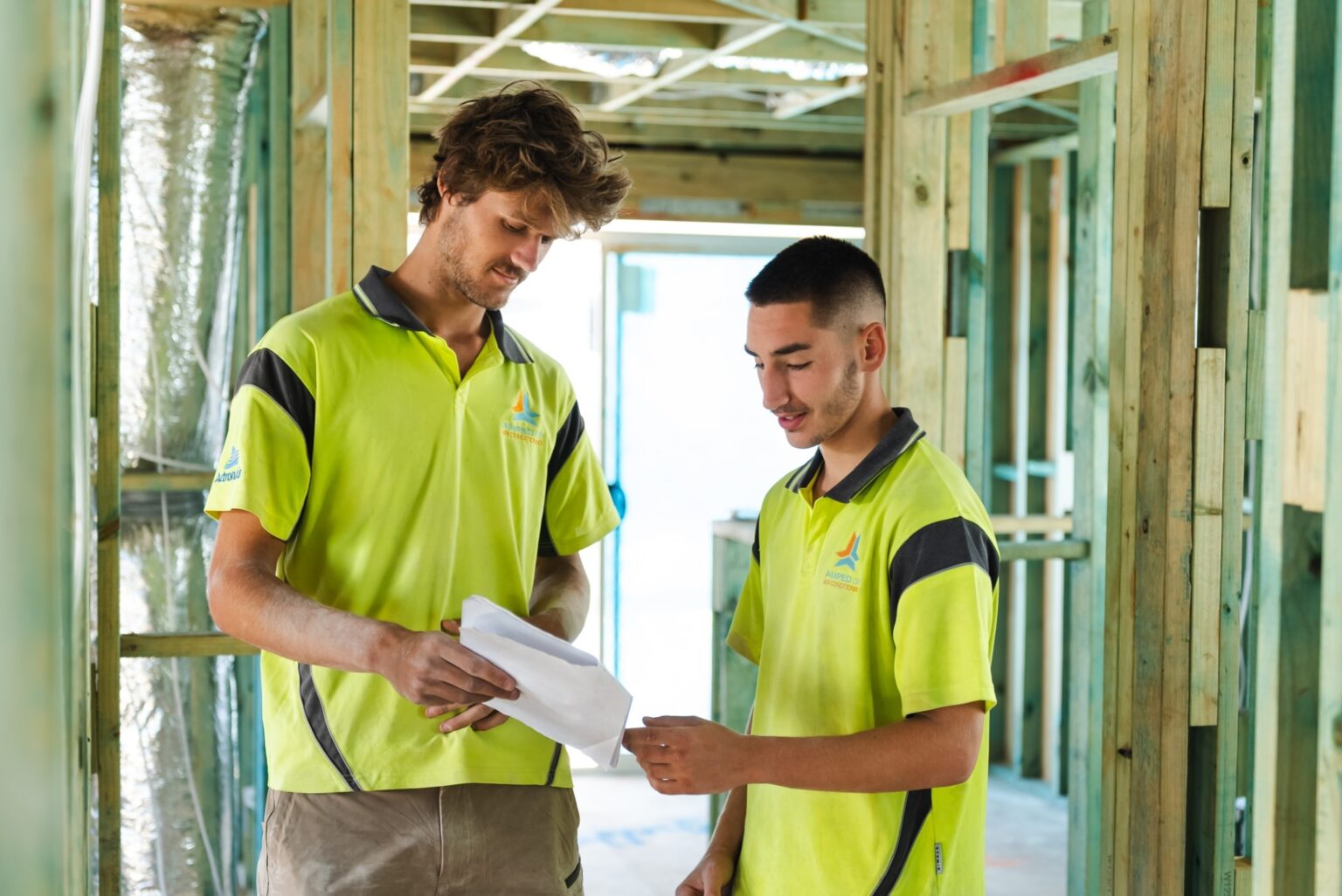 Two Amped Up Air crew members reviewing installation documents on site